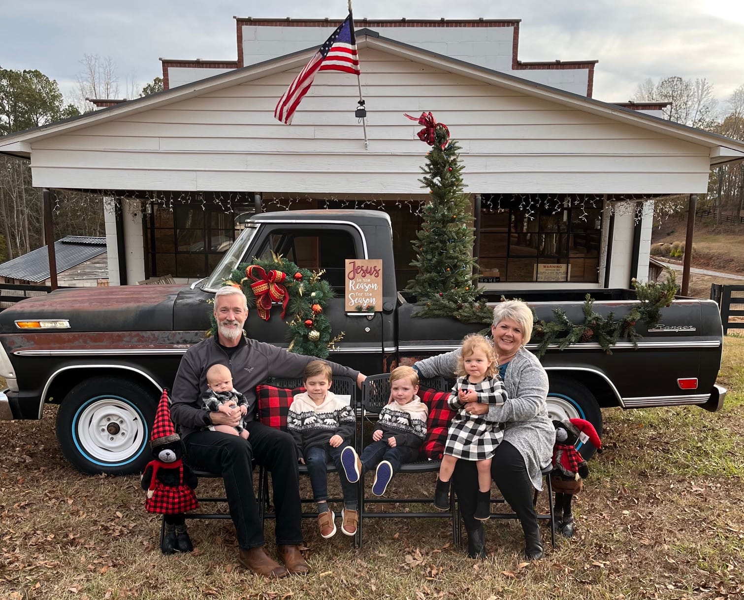 John and Lashelle Thompson with their grandchildren in front of the restored general store at Christmas