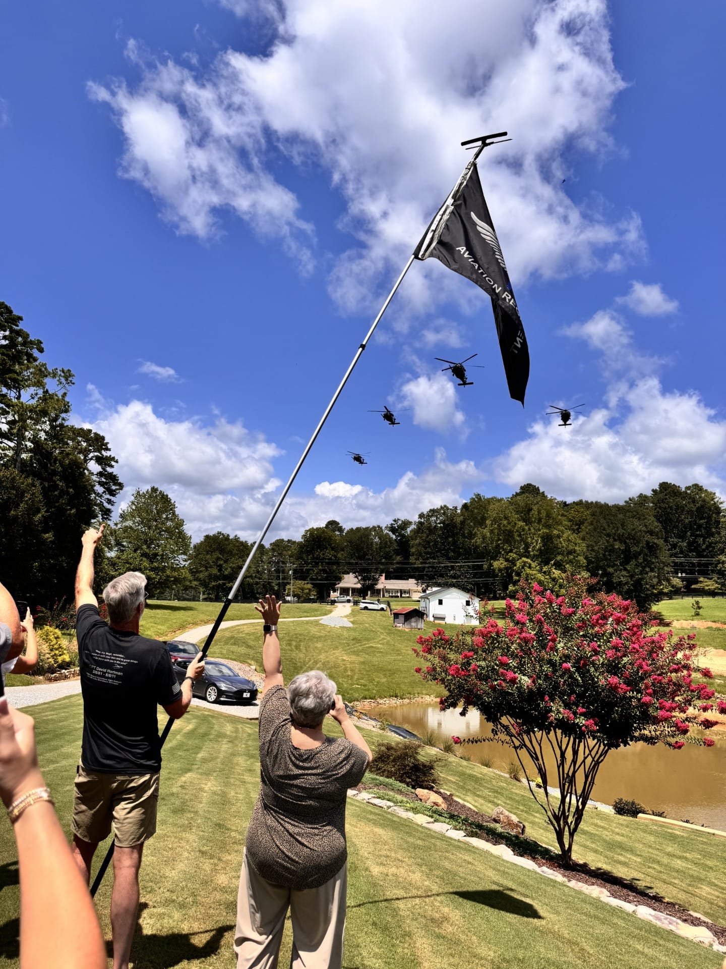 160th Special Operations Aviation Regiment Night Stalkers helicopter formation flyover with regimental flag in foreground