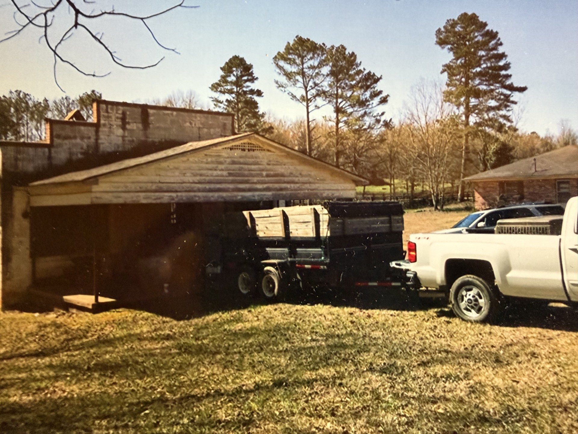 The back of the general store before restoration — old barn structure, trailer, and weathered roofline